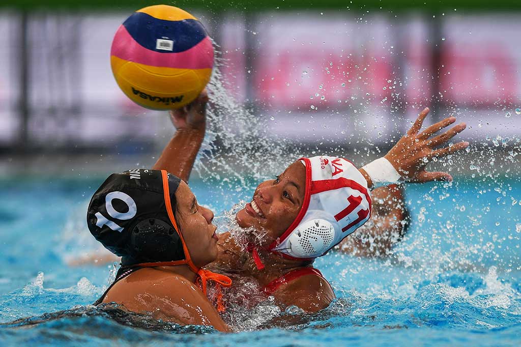 Atlet polo air putri Indonesia Rani Raida (kanan) berebut bola dengan atlet tuan rumah Trisha Then Chiah Huey pada perebutan medali perunggu yang digelar di National Aquatic Center, Bukit Jalil, Sabtu (19/8/2017).