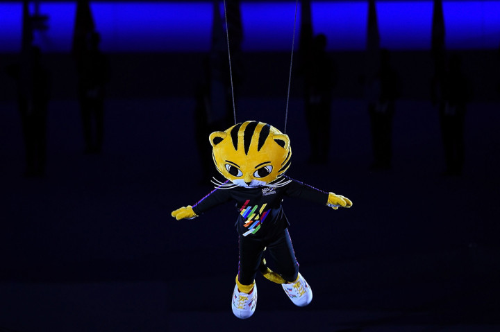 Usai penari undur diri dari tengah lapangan. Para penonton disajikan aksi Rimau, maskot SEA Games 2017, terbang di udara. Ketika turun, maskot berwajah Harimau itu disambut kembali oleh para penari. AFP/ MANAN VATSYAYANA