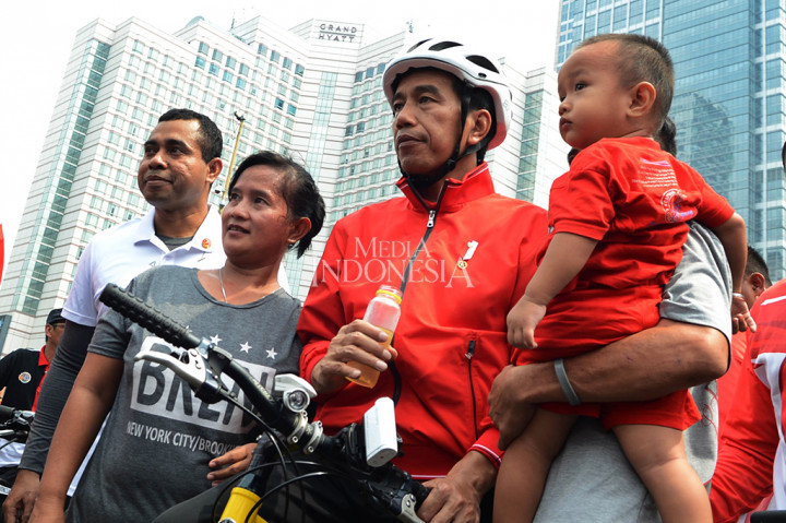 Presiden Jokowi berfoto dengan masyarakat diselah-selah berolahraga sepeda santai saat Car Free Day di Bundaran HI, Jakarta. MI/MOHAMAD IRFAN 