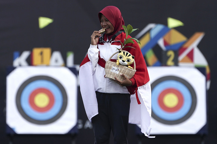 Atlet panahan Indonesia Diananda Choirunnisa membawa bendera merah putih seusai mengalahkan lawannya asal Filipina Nicole Marie Tagle pada final nomor recurve putri di Synthetic Turf Fild, Kawasan Bukit Jalil, Malaysia.
