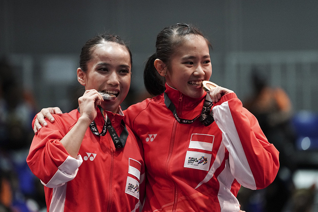 Atlet Wushu Indonesia Felda Elfira Santoso dan Monica Fransisca Sugianto menggigit medali ketika penganugerahan juara Wushu nomor Daoshu putri SEA Games XXIX di KLCC, Kuala Lumpur, Malaysia. Felda Elfira berhasil meraih medali emas dan Monica Fransisca merebut medali perak.