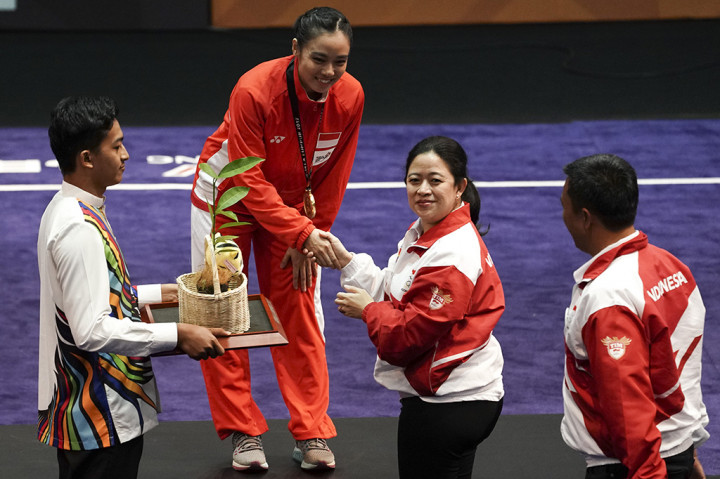 Menko PMK Puan Maharani disaksikan Menpora Imam Nahrawi menyerahkan medali kepada atlet wushu Indonesia Lindswell Kwok ketika upacara penyerahan medali wushu nomor Taijijian putri di KLCC, Kuala Lumpur, Malaysia.

