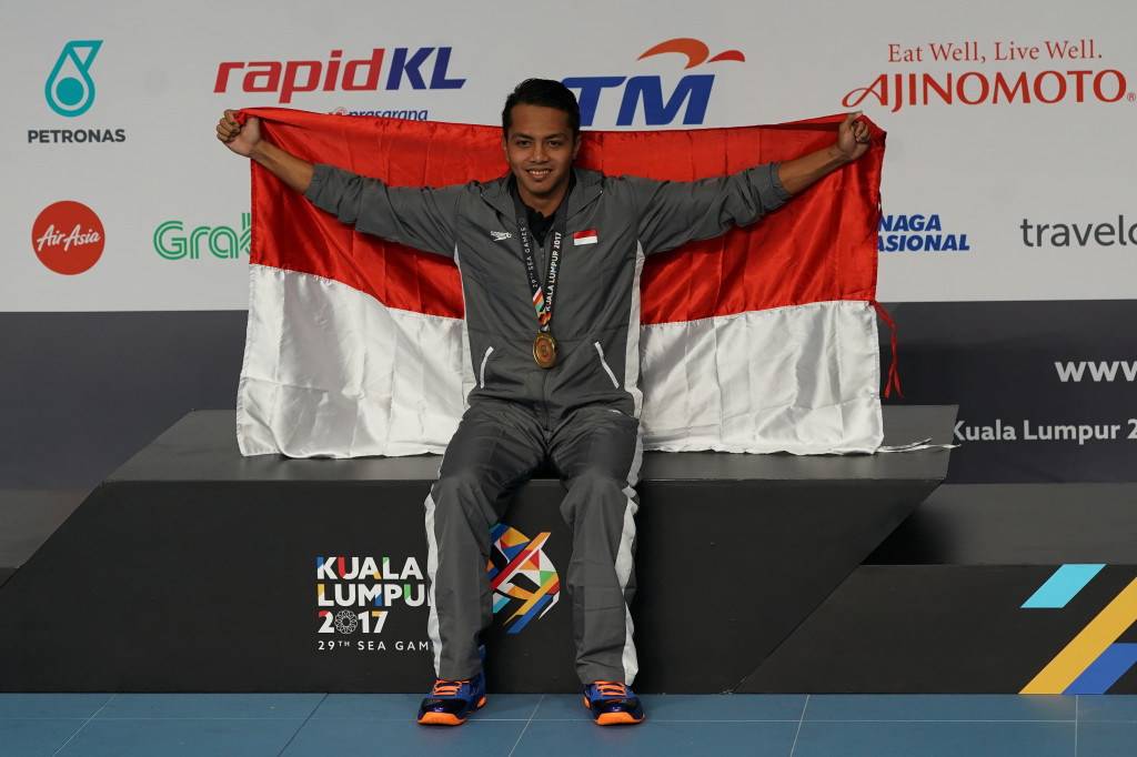 I Gede Siman Sudarwata 'mengibarkan' Merah Putih di atas podium seusai upacara pengalungan medali emas.