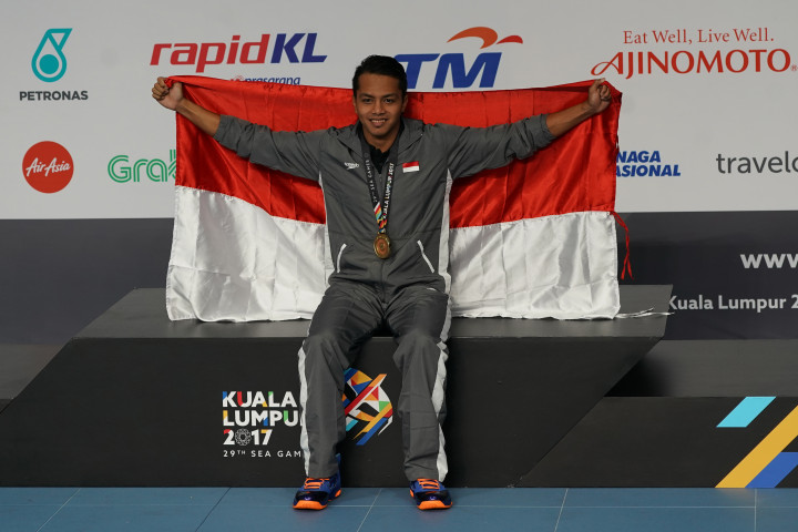 I Gede Siman Sudarwata 'mengibarkan' Merah Putih di atas podium seusai upacara pengalungan medali emas.