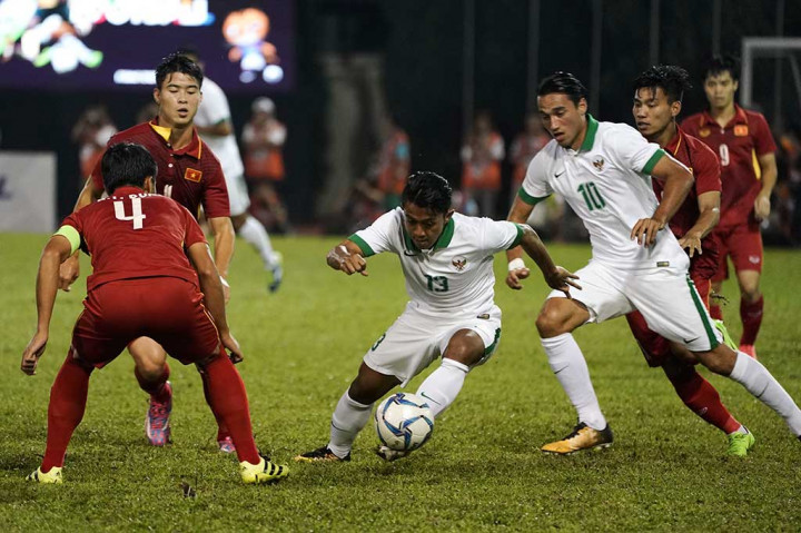 Gelandang Timnas Indonesia Febri Haryadi (tengah) berusaha melewati pemain Timnas Vietnam Bui Tien Dung.