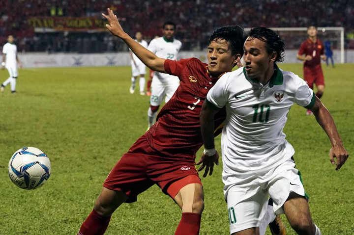 Ezra Walian (kanan) berebut bola dengan pemain Timnas Vietnam Hoang Van Khanh.