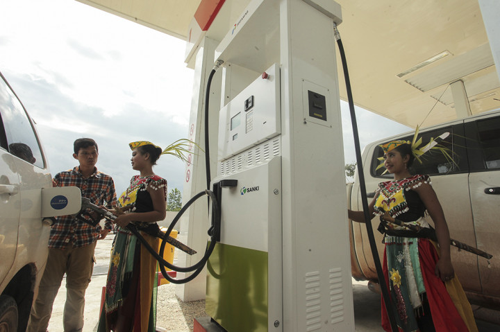 Petugas SPBU berbusana adat dayak melayani pembelian BBM saat peresmian SPBU Modular di Telaga Pulang, Kalimantan Tengah.