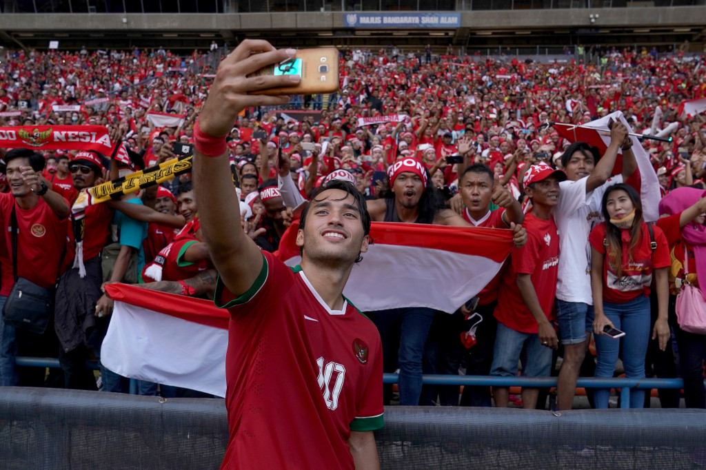 Pencetak gol pertama bagi Indonesia, Ezra Walian melakukan swafoto bersama pendukung usai laga melawan Kamboja.