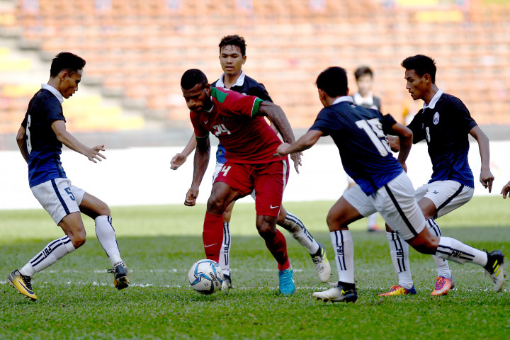 Marinus Mariyanto Wanewar (kedua kiri) menggiring bola dibayangi empat pemain Kamboja pada laga terakhir penyisihan grub B SEA Games XXIX Kuala Lumpur di Stadion Shah Alam, Selangor