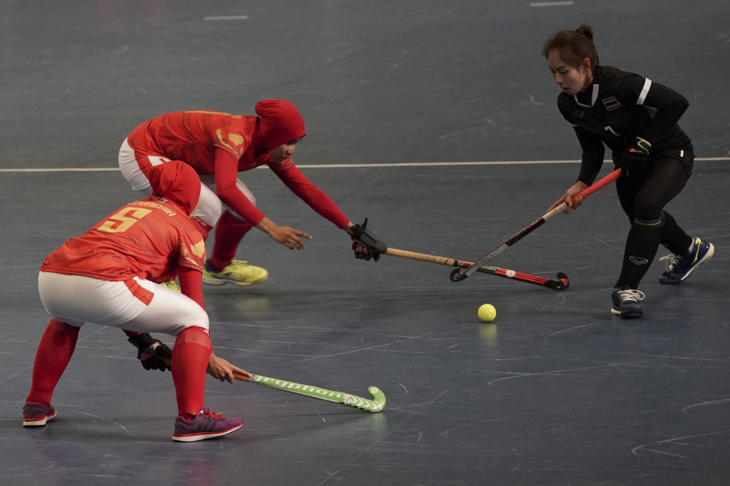 Dewi Andriani (tengah) dan Annur El Islamy berusaha menghentikan pergerakan atlet Tikhamporn Sakupinthak (kanan) dalam final hoki indoor putri SEA Games XXIX