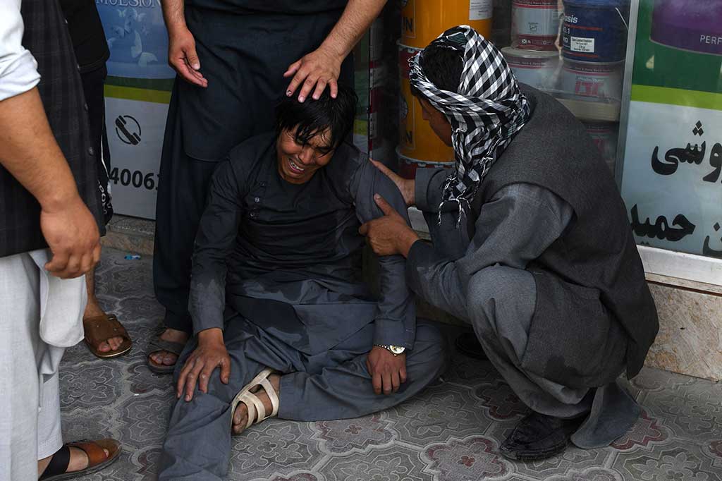 Seorang pria menangis setelah anggota keluaganya turut menjadi korban serangan bom bunuh diri.