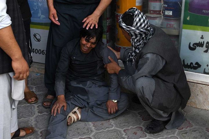 Seorang pria menangis setelah anggota keluaganya turut menjadi korban serangan bom bunuh diri.