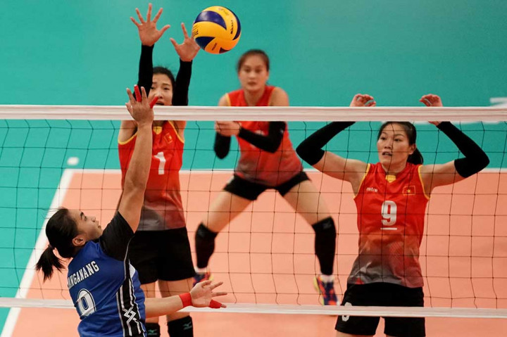 Pevoli putri Indonesia Aprilia Manganang (kiri) melakukan smash yang diblok oleh pevoli Vietnam Doan Thi Xuan (kiri) dan Nguyen Thi Ngoc Hoa pada semi final bola voli putri SEA Games XXIX Kuala Lumpur di MITEC, Kuala Lumpur.