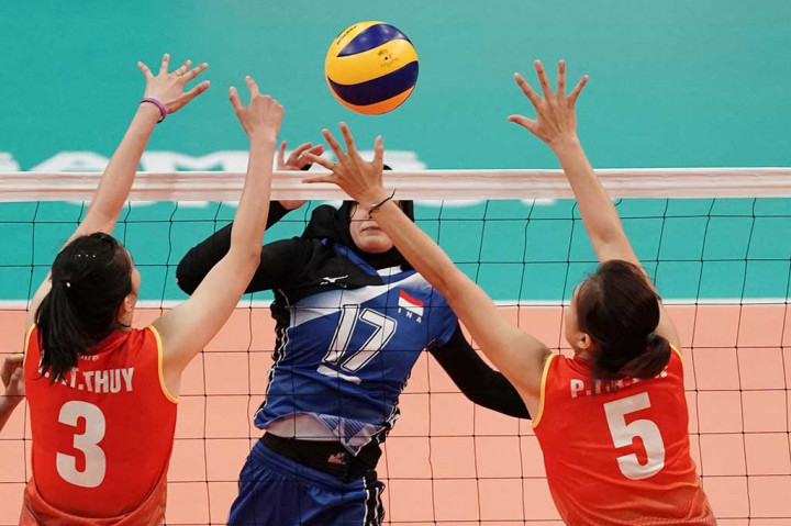 Pevoli putri Indonesia Wilda Siti Nurfadhilah (tengah) melepaskan smash yang diblok oleh pevoli Vietnam Tran Thi Thanh Thuy (kiri) danPham Thi Kim Hue.