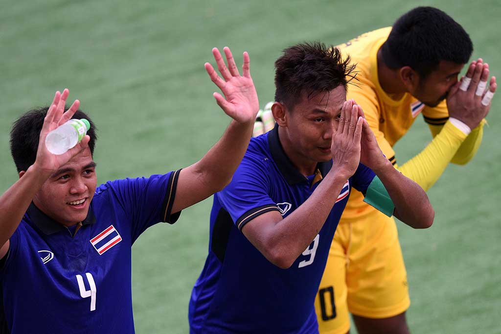 Chenrop Samphaodi (tengah) bersama rekan-rekannya memberikan hormat kepada suporter Thailand.