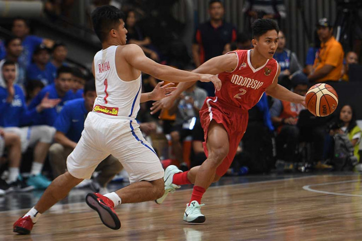 Pebasket Indonesia Hardianus Lakudu berusaha melewati pebasket Filipina Kiefer Isaac Ravena.
