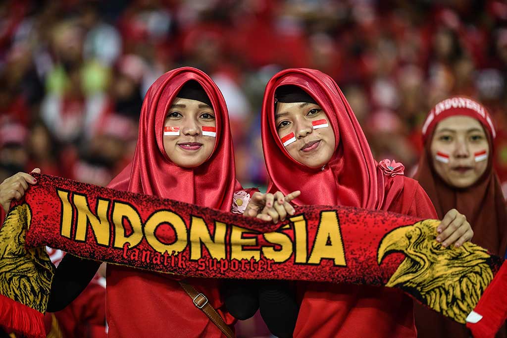 Suporter putri turut mendukung perjuangan Garuda Muda melawan Malaysia di  Stadion Majlis Perbandaran Selayang. AFP/Mohd Rasfan