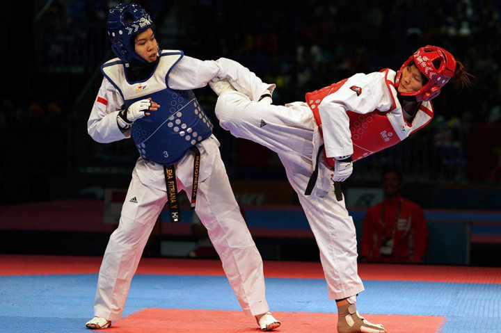 Shaleha Fitriana (kiri) menepis tendangan dari atlet taekwondo Vietnam Ha Thi Nguyen. Shaleha kalah dengan skor telak 4-9, 6-13, 10-2 