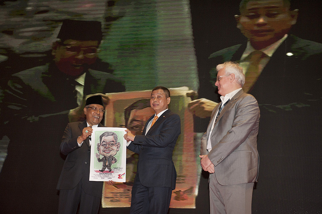 Menteri Energi Sumber Daya Mineral Ignasius Jonan memperlihatkan lukisan dirinya bersama Ketua Indonesia Commodity and Derivatives Exchange (ICDX) KH Said Aqil Siroj dan CEO ICDX Lamon Rutten pada pembukaan Konferensi Timah Indonesia 2017 di Nusa Dua, Bali.