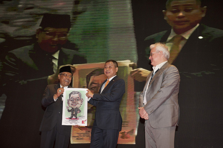 Menteri Energi Sumber Daya Mineral Ignasius Jonan memperlihatkan lukisan dirinya bersama Ketua Indonesia Commodity and Derivatives Exchange (ICDX) KH Said Aqil Siroj dan CEO ICDX Lamon Rutten pada pembukaan Konferensi Timah Indonesia 2017 di Nusa Dua, Bali.