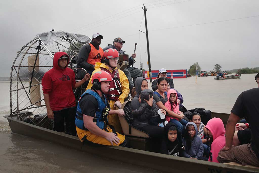 Warga dievakuasi menggunakan perahu dari lingkungan yang dilanda banjir, sisa-sisa badai Harvey, di Houston, Texas, Senin (28/8/2017) waktu setempat. AFP/Scott Olson/Getty Images