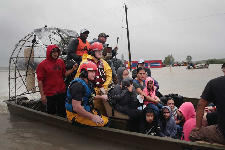 Warga dievakuasi menggunakan perahu dari lingkungan yang dilanda banjir, sisa-sisa badai Harvey, di Houston, Texas, Senin (28/8/2017) waktu setempat. AFP/Scott Olson/Getty Images