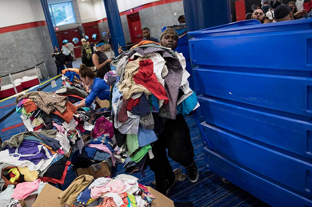 Relawan memilah-milah pakaian bekas yang akan disumbangkan di tempat penampungan di George R. Brown Convention Center. 