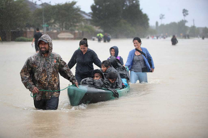 Warga meninggalkan tempat tinggal mereka yang dilanda banjir di wilayah Houston, Texas. AFP/Scott Olson/Getty Images
