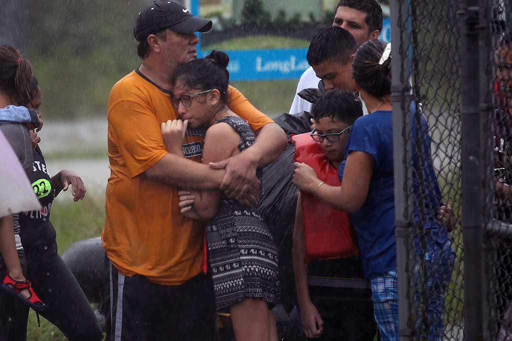 Penduduk yang menggigil kedinginan tengah menunggu kapal penyelamat untuk meninggalkan rumah mereka yang terendam banjir. AFP/Joe Raedle/Getty Images