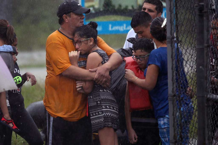 Penduduk yang menggigil kedinginan tengah menunggu kapal penyelamat untuk meninggalkan rumah mereka yang terendam banjir. AFP/Joe Raedle/Getty Images