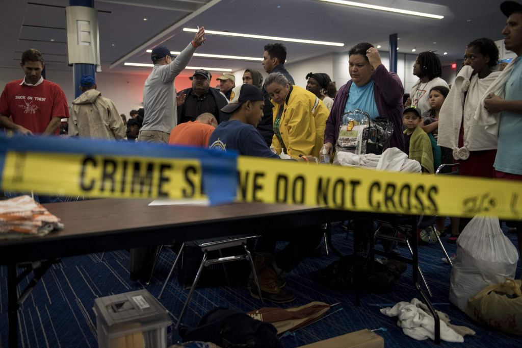 Warga mengantri mendaftarkan diri untuk masuk ke pengungsian. Petugas meminta data adakah warga dengan kondisi tertentu yang membutuhkan penanganan khusus. AFP PHOTO / Brendan Smialowski
