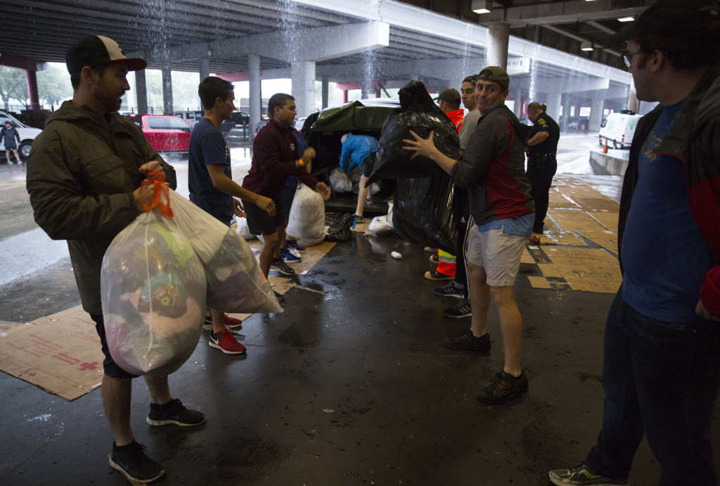 Sukarelawan menerima donasi pakaian untuk dibagikan kepada para pengungsi. Hujan yang mengguyur Houston diperkirakan baru ada merekan beberapa hari ke depan. 
