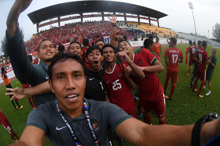 Asisten pelatih Bima Sakti (kedua kiri) bersama beberapa pemain dan ofisial Timnas U-22 Indonesia melakukan swafoto dengan kamera pewarta foto Antara usai mengalahkan Timnas U-22 Myanmar. 
