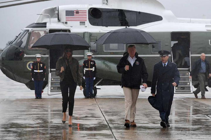 Trump bersama Melania berjalan menuju pesawat Air Force One di Andrews Air Force Base, Maryland. AFP/Jim Watson