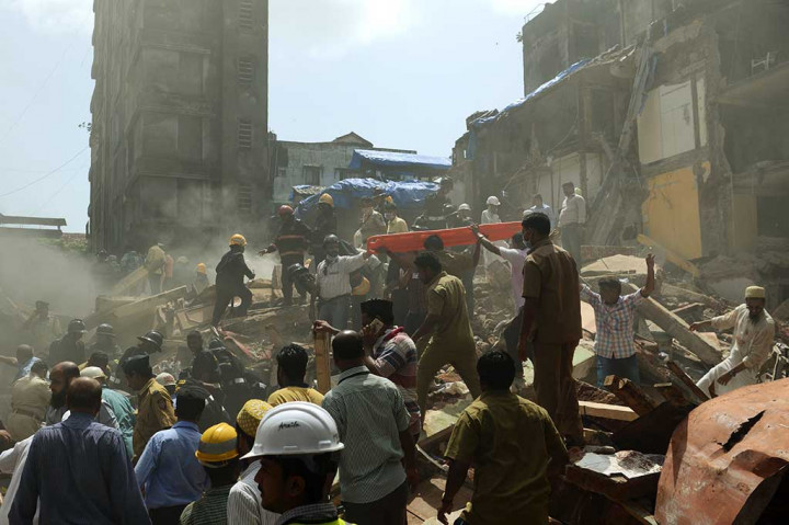 Puluhan petugas berusaha mengevakuasi para korban di reruntuhan gedung lima lantai di Mumbai, India, Kamis (31/8/2017).