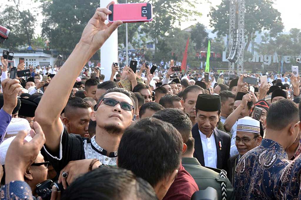 Seperti biasa setiap kunjungannya, Jokowi selalu dikerubuti masyarakat yang ingin berjabat tangan dan berfoto.