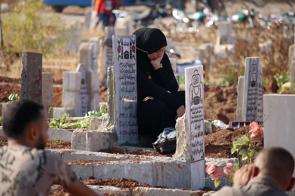 Seorang wanita termenung di depan pusara kerabatnya di Kota Daraa, Suriah Selatan. AFP/Mohamad Abazeed
