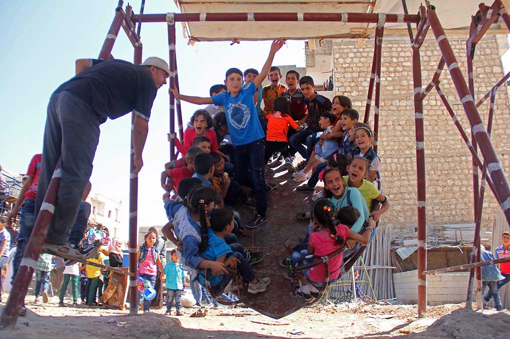 Anak-anak bergembira saat bermain ayunan di Kota Idlib. AFP/Omar Haj Kadour