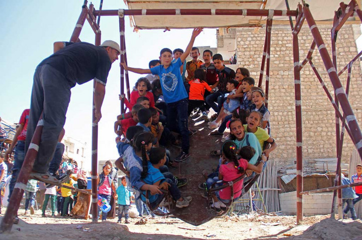 Anak-anak bergembira saat bermain ayunan di Kota Idlib. AFP/Omar Haj Kadour