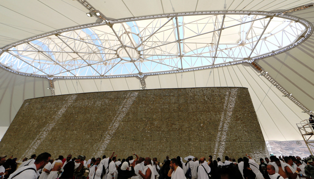 Melempar jumroh di lantai empat Jumarat Mina. Tugu simbol iblis dan sasaran lemparan jumroh dibuat berupa tabung oval lebar memjulang dari basement.