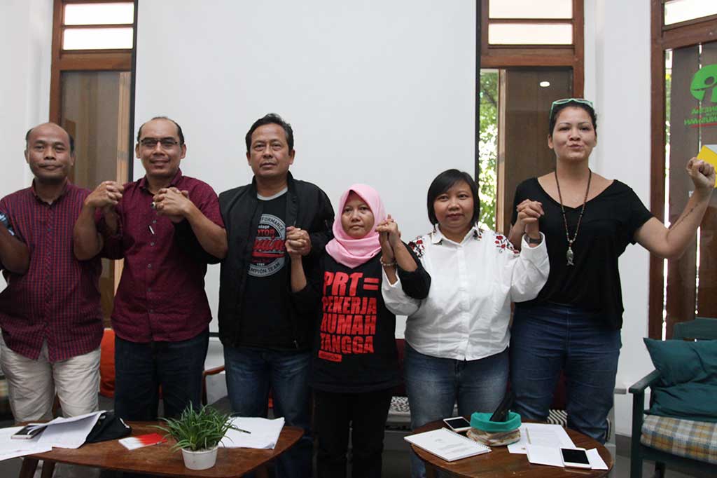 Direktur Eksekutif Migrant Care Wahyu Susilo (kiri), Kepala Desa Dukuh Dempok, Jember Miftahul Munir (kedua kiri), mitra Migrant Care dari Sari Solo Mulyadi,(ketiga kiri) Koordinator Divisi Kebijakan Migrant Care Siti Badriyah (ketiga kanan), pendiri Migrant Care Anis Hidayah (kedua kanan) dan Ambasador Migrant Care Melanie Subono (kanan) saling bergandengan tangan usai memberikan keterangan pers. ANTARA/Reno Esnir