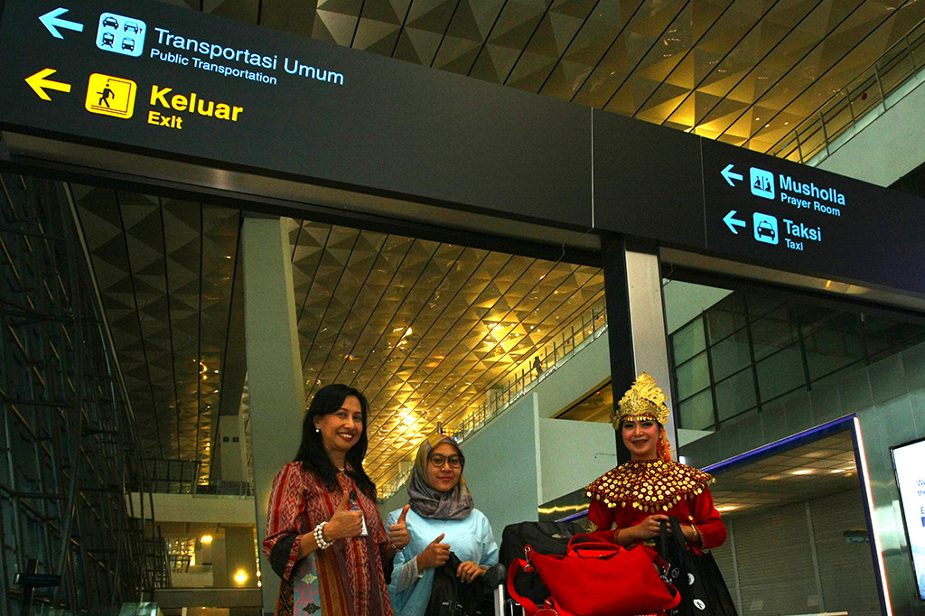 Direktur Airport Service PT Angkasa Pura II Ituk Herarindri memberikan cenderamata kepada penumpang pesawat saat merayakan Hari Pelanggan Nasional 2017 di Bandara Soekarno Hatta, Tangerang, Banten. Kegiatan itu sebagai bentuk wujud kepedulian kepada para penumpang dan pengguna jasa bandara. ANTARA/Muhammad Iqbal