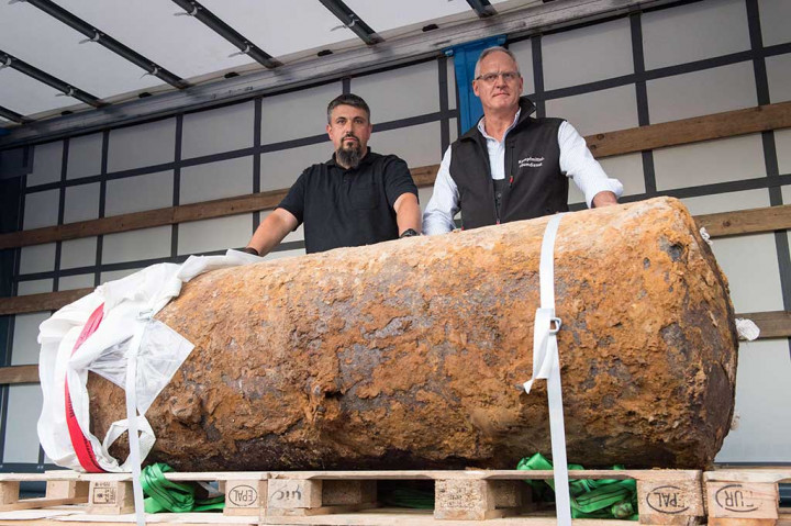 Ahli bahan peledak Dieter Schwetzler (kiri) dan Rene Bennert berpose di belakang bom raksasa (Blockbuster) peninggalan Perang Dunia II yang berhasil mereka jinakkan, di Frankfurt, Jerman (Minggu (3/9/2017) waktu setempat.  AFP/Thomas Lohnes