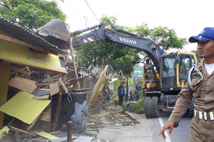 Tim eksekusi dari Satuan Polisi Pamong Praja (Sat Pol PP) Kabupaten Bogor dibantu alat berat melakukan pembongkaran bangunan yang berada di bahu jalan jalur Puncak, Cisarua, Kabupaten Bogor, Selasa (5/9/2017). 