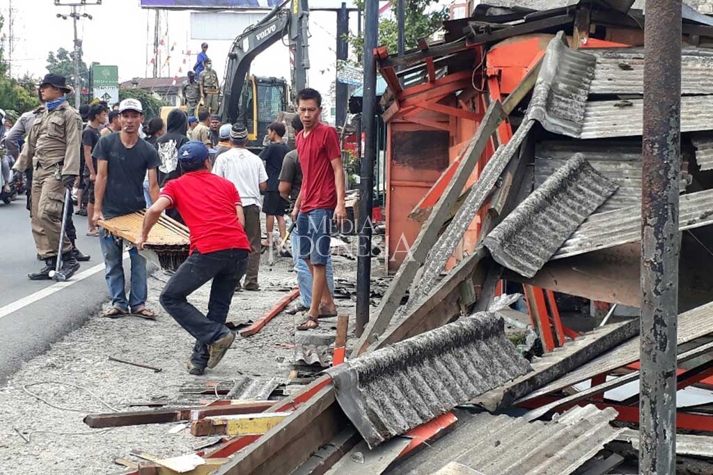 Warga adu cepat dengan tim eksekusi dari Satpol PP Kabupaten Bogor yang menggunakan alat berat membongkar toko/lapaknya. 