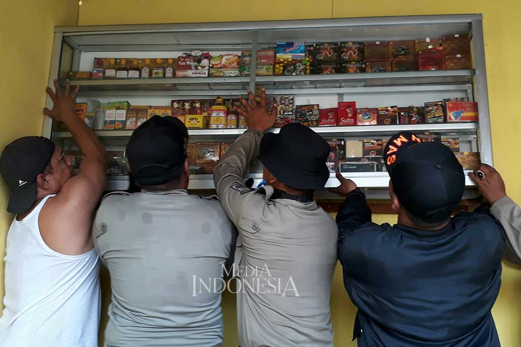 Warga dibantu petugas Satpol PP berusaha membongkar barang-barangnya.