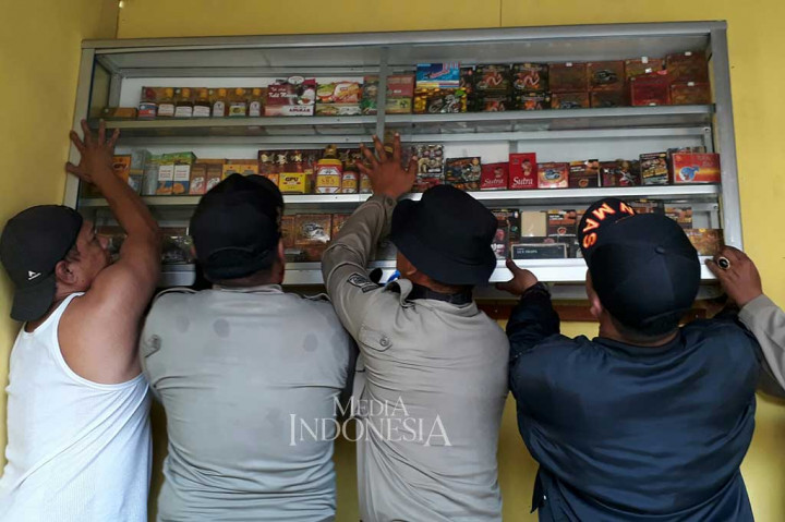 Warga dibantu petugas Satpol PP berusaha membongkar barang-barangnya.