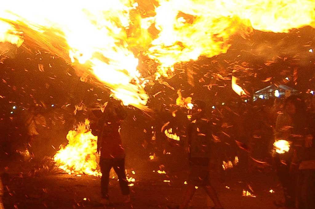 Peserta saling serang menggunakan obor pada tradisi perang obor di Desa Tegal Sambi, Tahunan, Jepara, Jawa Tengah, Senin (4/9/2017).