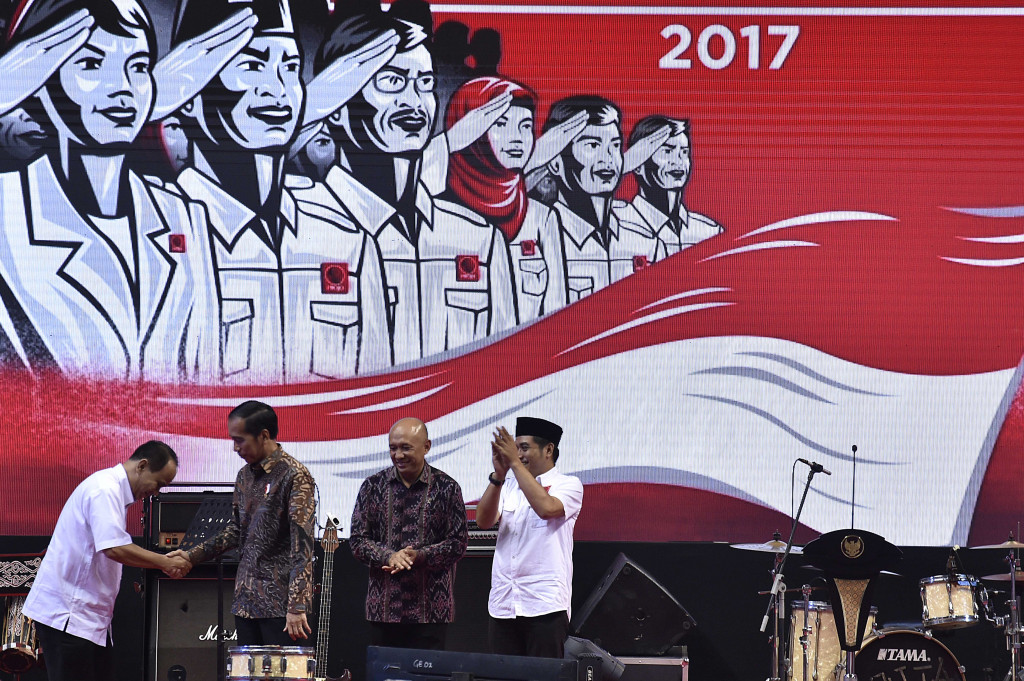 Presiden Jokowi berjabat tangan dengan Ketua Projo Budi Arie Setiadi disaksikan Kepala Staf Presiden Teten Masduki dan Ketua Panpel Rakernas III Projo Handoko. Tahun politik akan yang dimulai pada 2018 merupakan masa yang rawan manuver politik. 