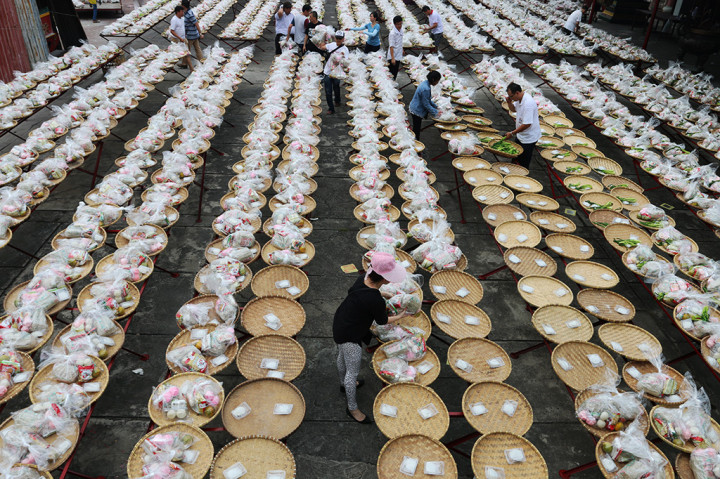 Umat Buddha keturunan Tionghoa menyusun makanan yang dikumpulkan dalam wadah sebelum pelaksanaan sembahyang leluhur.